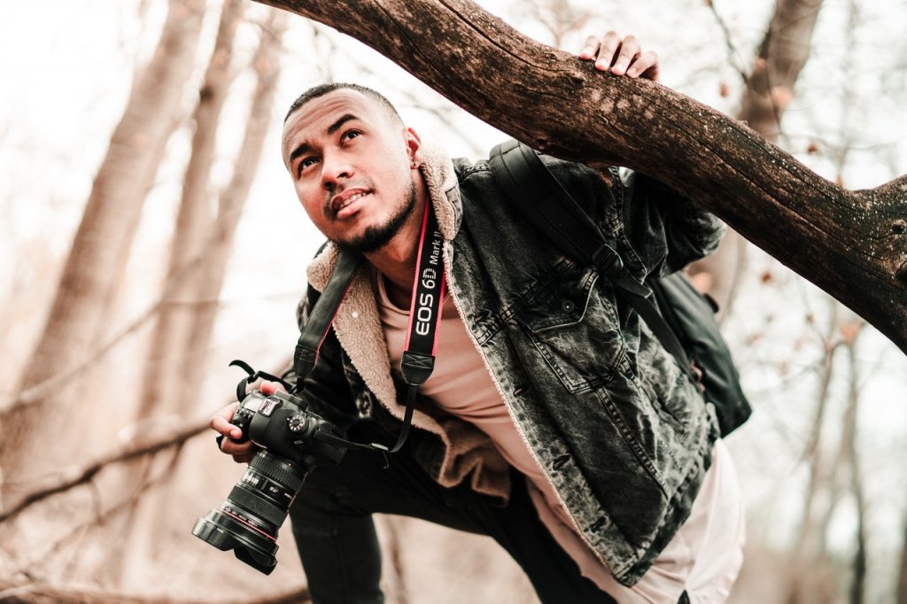 photographer holding tree branch